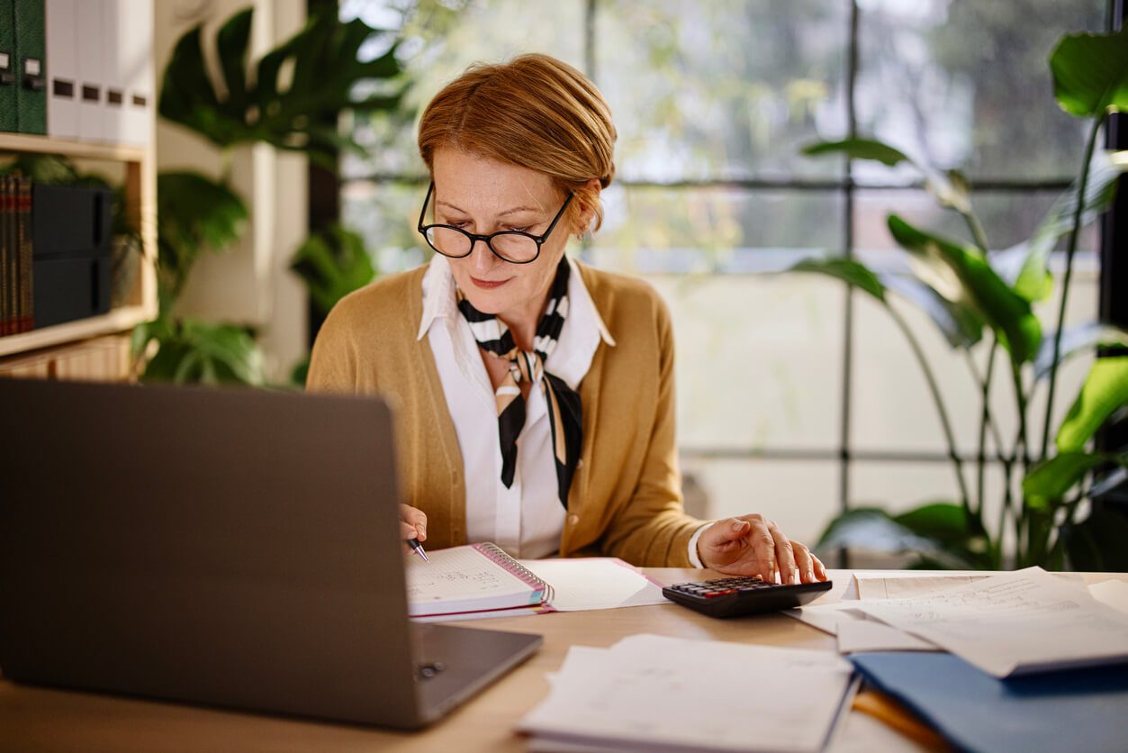 Middle aged businesswoman using laptop while working from home